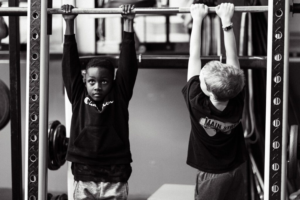 two young boys are working out in the gym