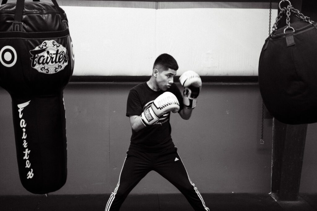 a young man is practicing boxing in a black and white photo