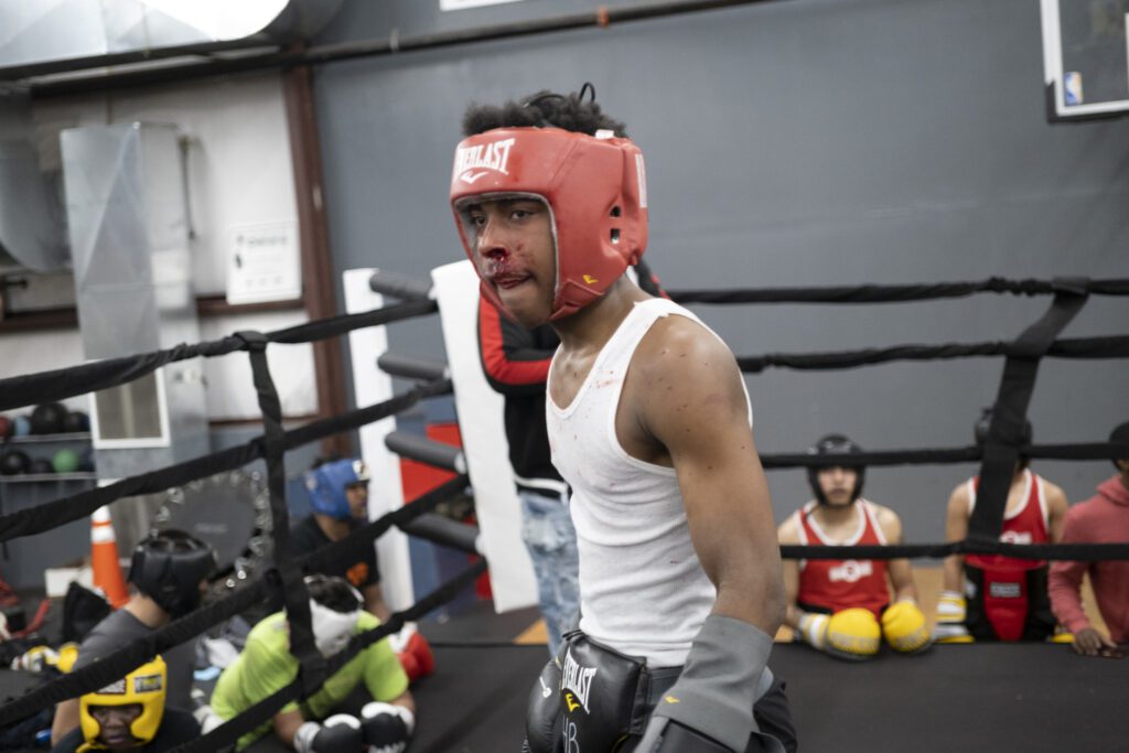 a man wearing boxing gloves and a red helmet