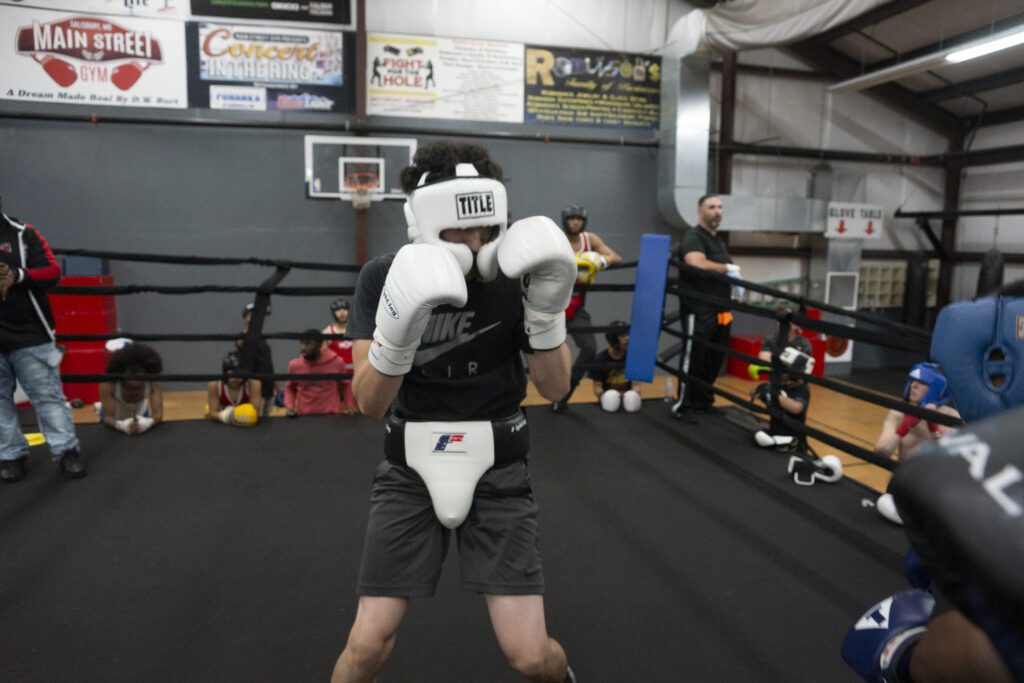 a man wearing boxing gloves in a gym