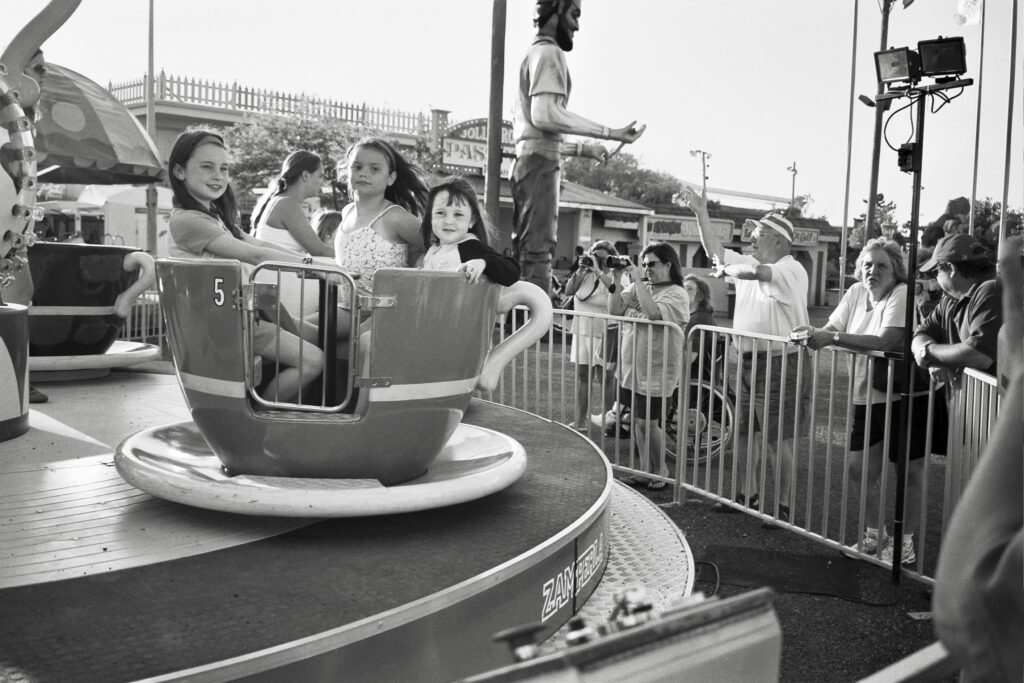 a black and white photo of people riding on a carnival ride