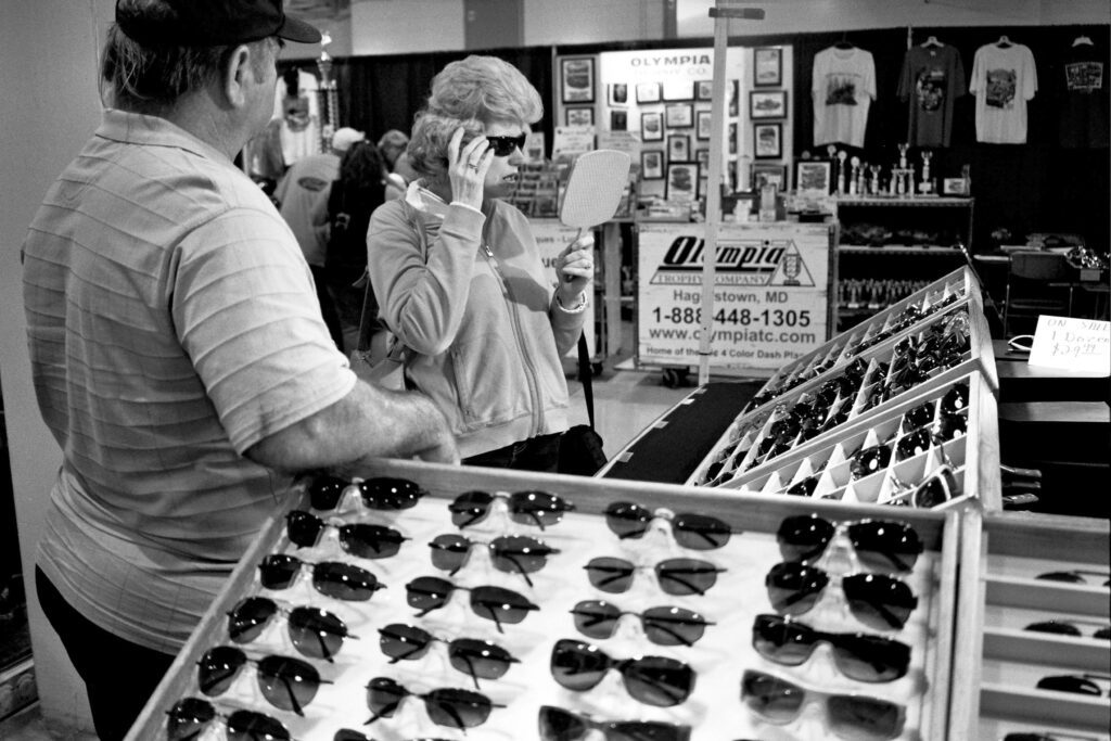 a man and woman looking at sunglasses in a store