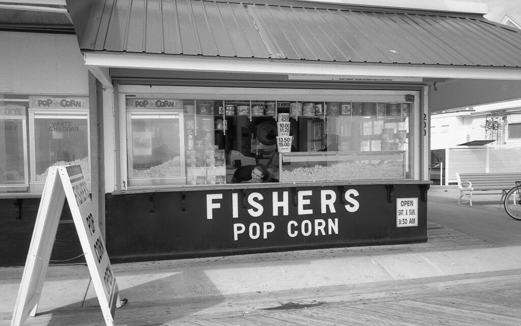 a black and white photo of a fisher's pop corn store