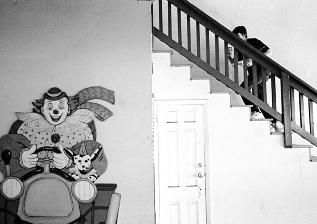 a black and white photo of a clown painted on the wall