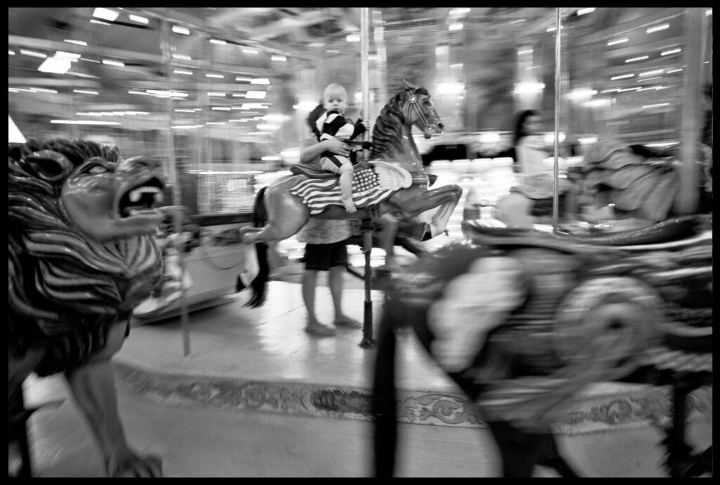 a black and white photo of a carousel with horses