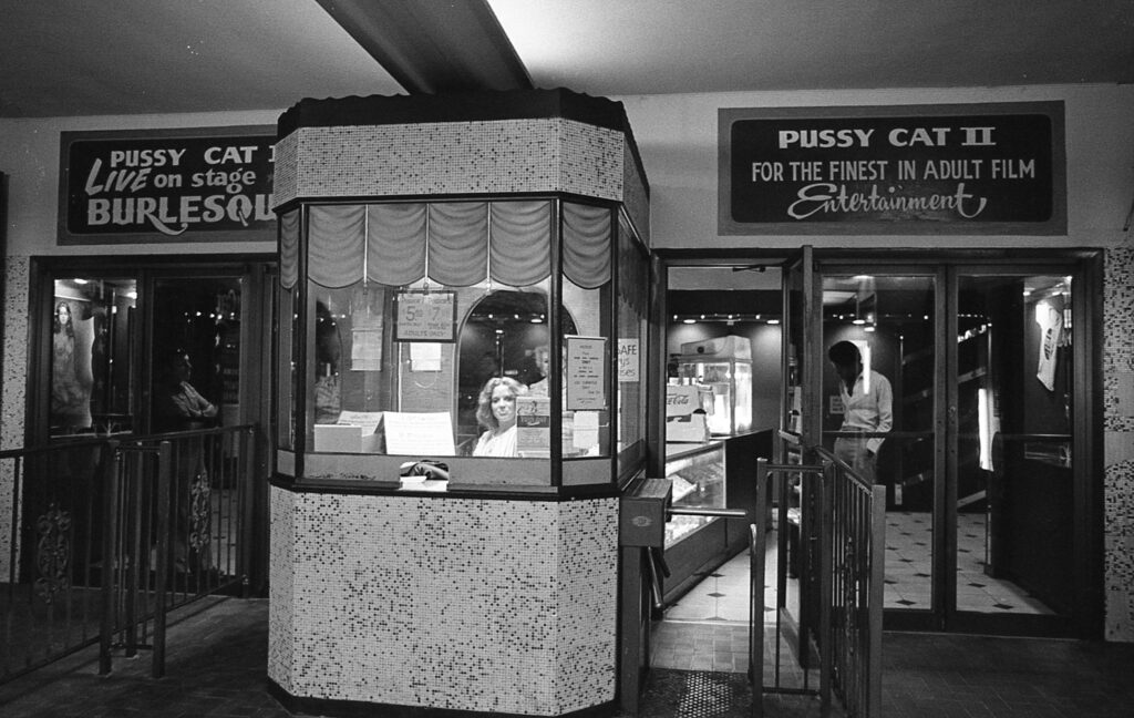 a black and white photo of a woman in a phone booth