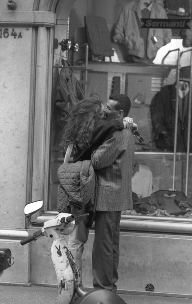 a man and woman kissing on the street