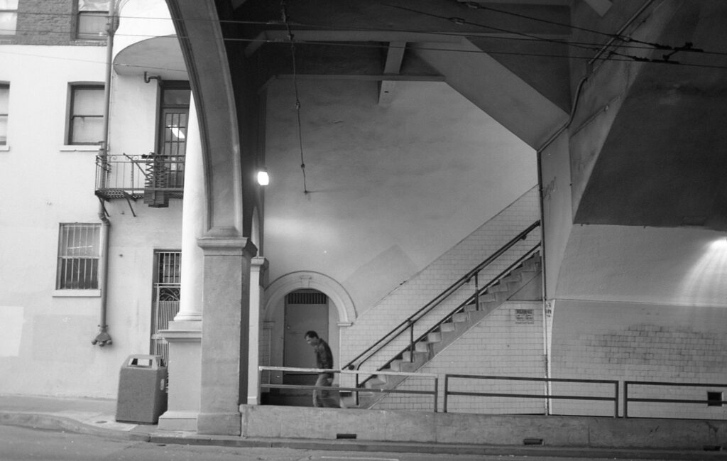 a black and white photo of a person walking up the stairs