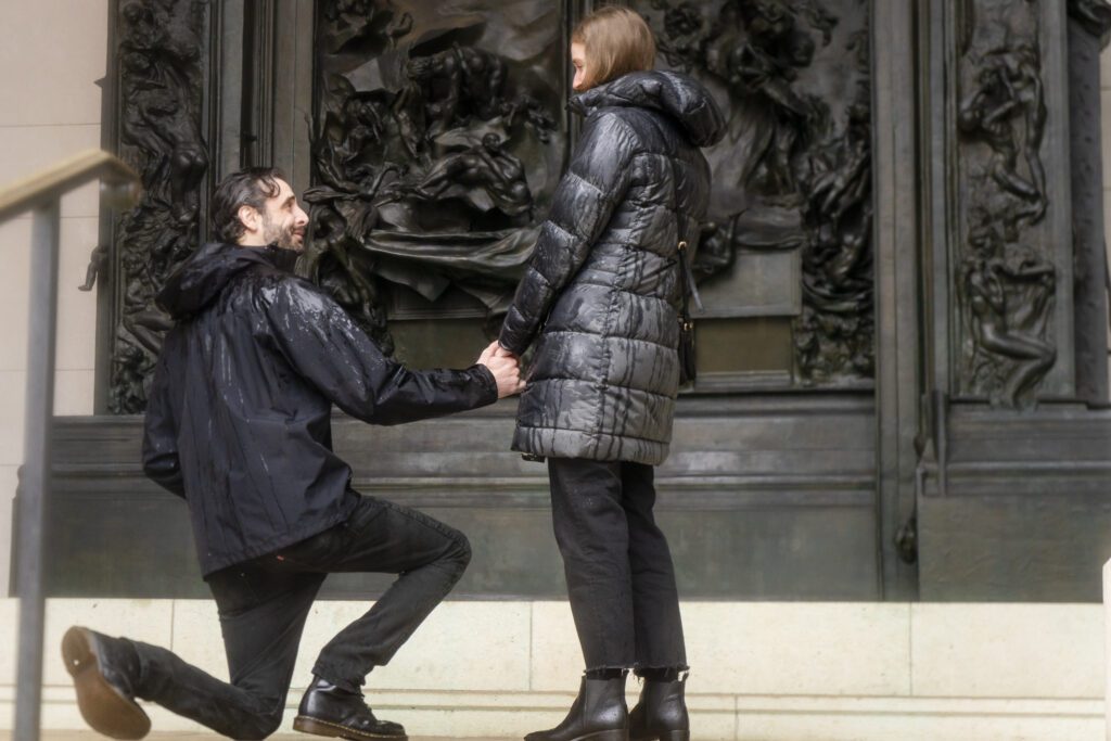 a man and woman holding hands in front of a building