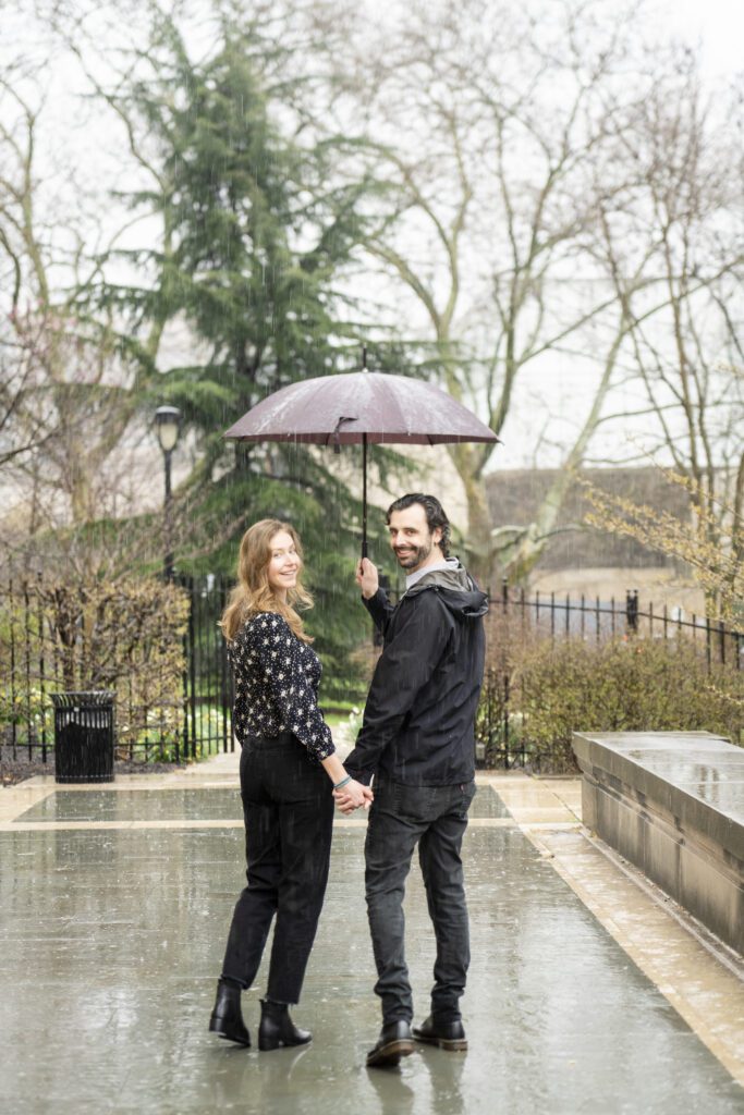 a man and woman holding an umbrella in the rain