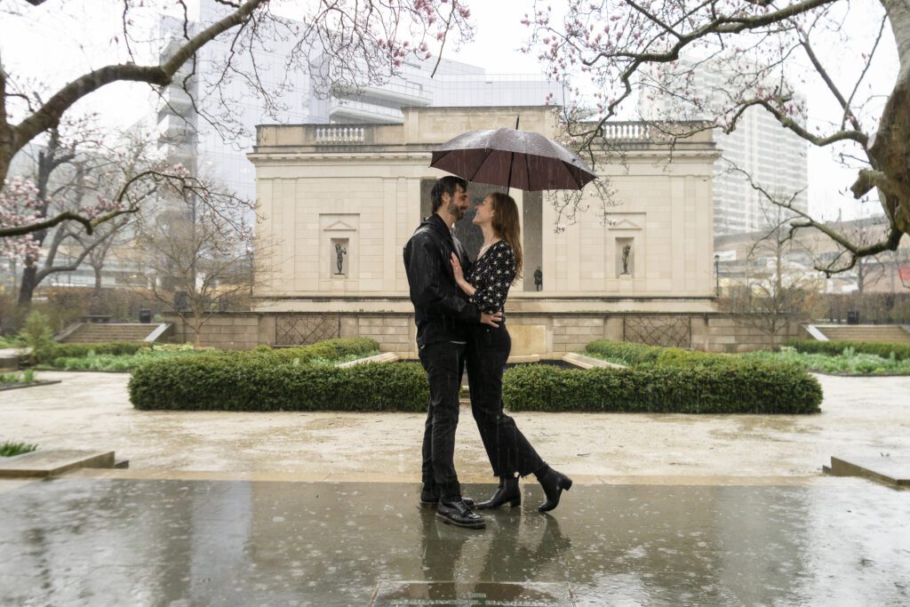 a man and woman standing under an umbrella in the rain