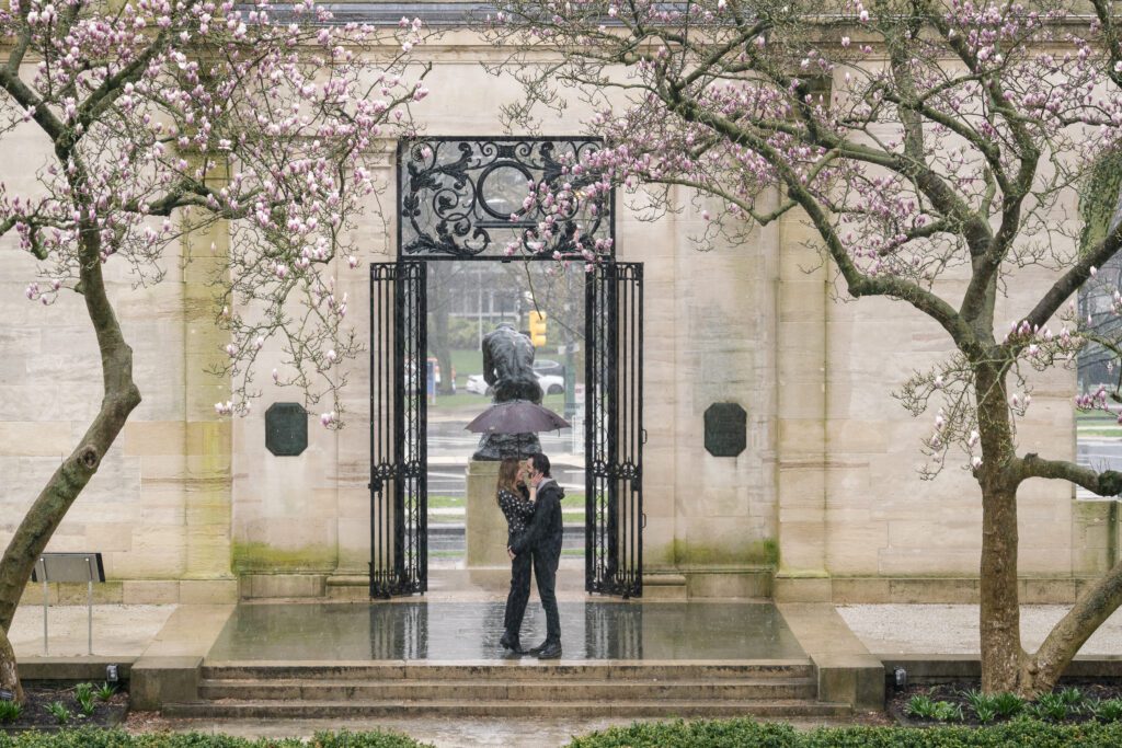 two people standing under an umbrella in the rain