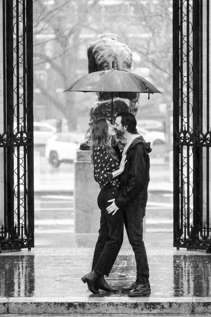 a couple kissing under an umbrella in the rain