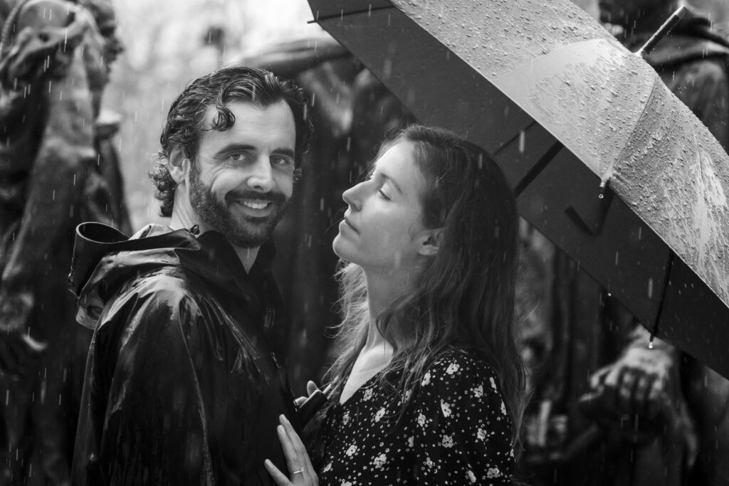 a man and woman standing under an umbrella in the rain