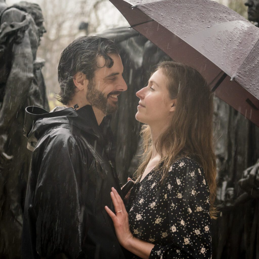 a man and woman standing under an umbrella