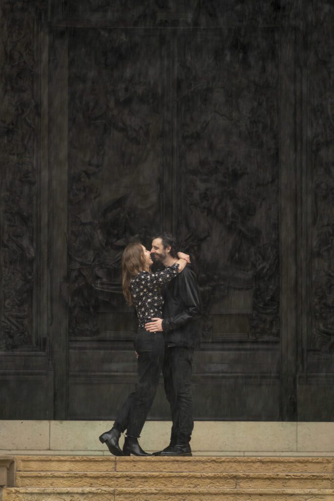 a man and woman are kissing on the steps