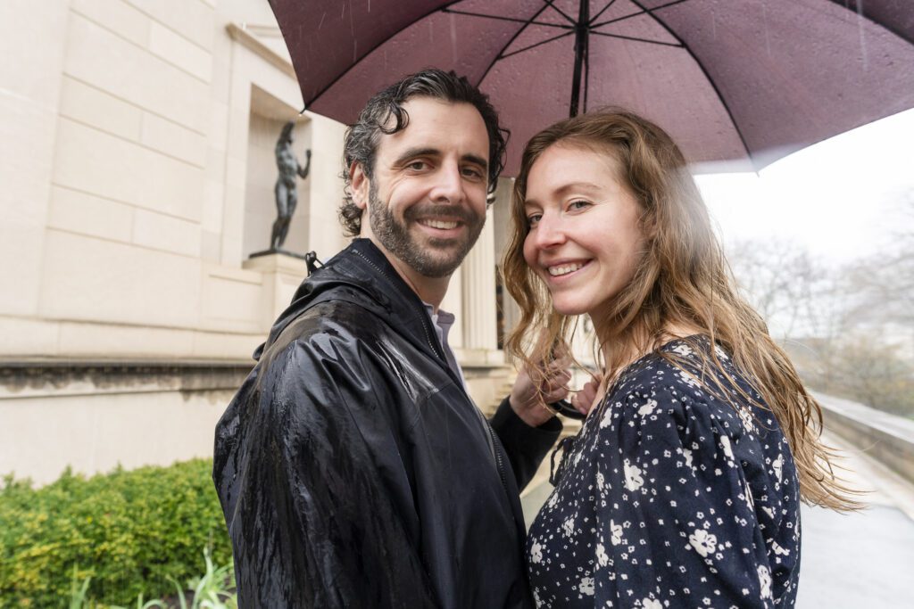 a man and woman standing under an umbrella