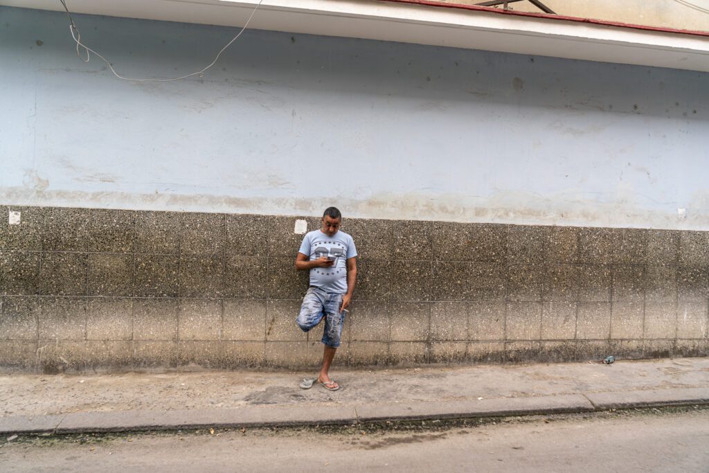 a man standing on the side of a road next to a building