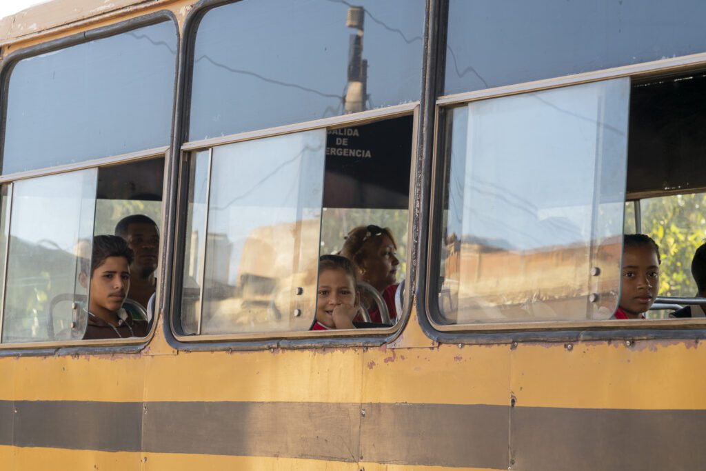 a group of children are looking out the window of a bus