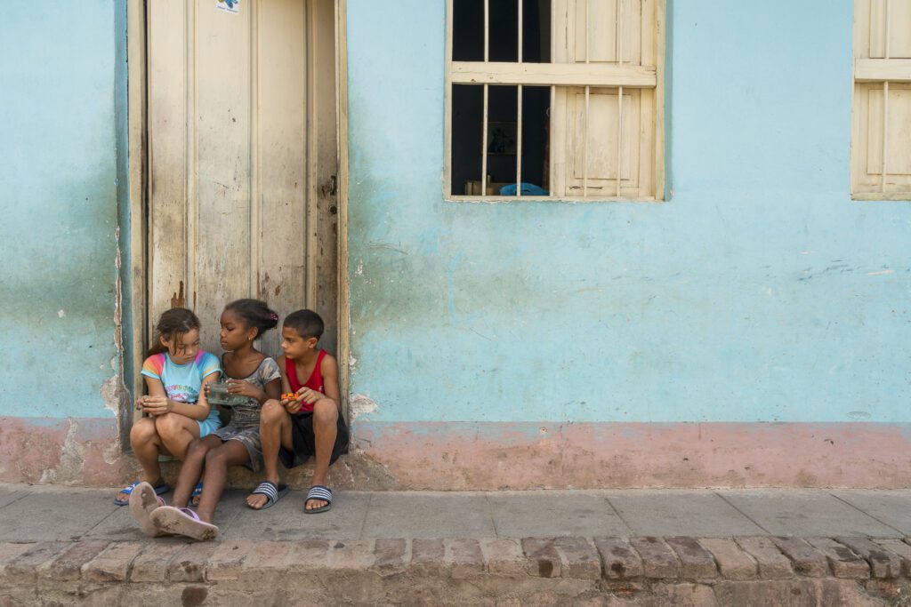 a group of children sitting on the side of a building