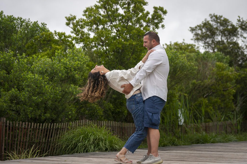 a man and a woman dancing on a dock