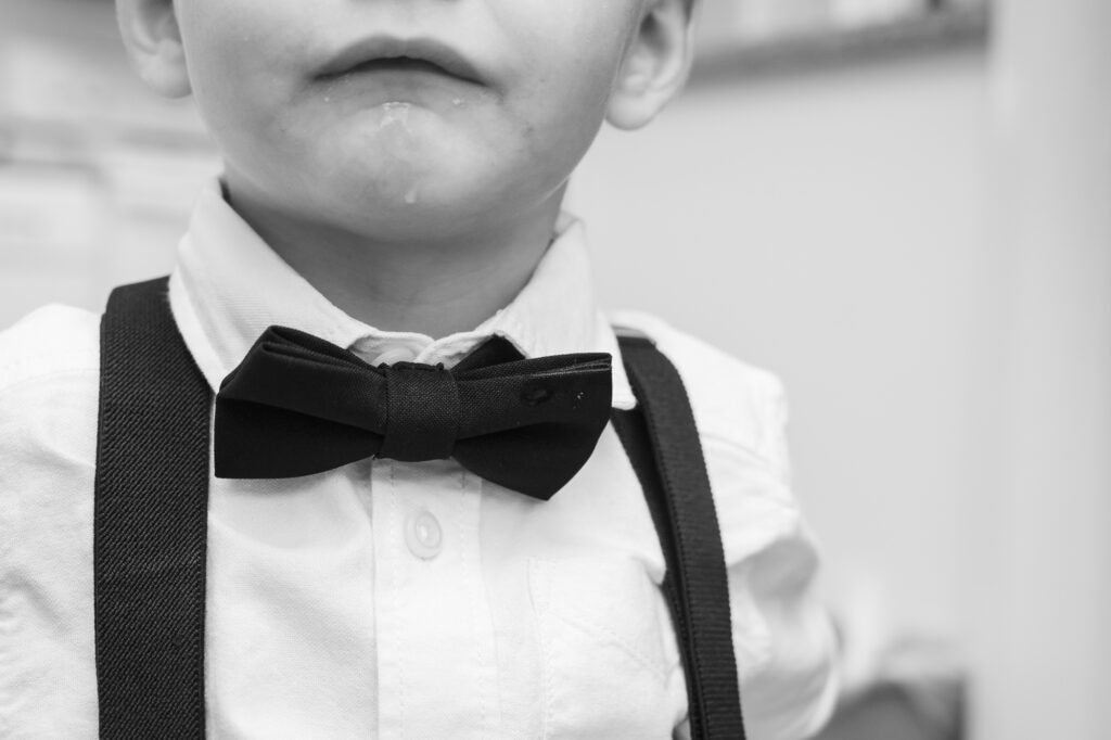 a young boy wearing a bow tie and suspenders