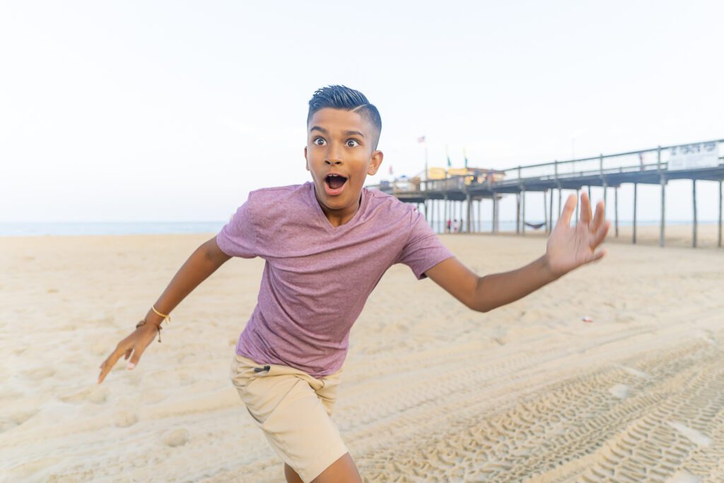 a young man is running on the beach