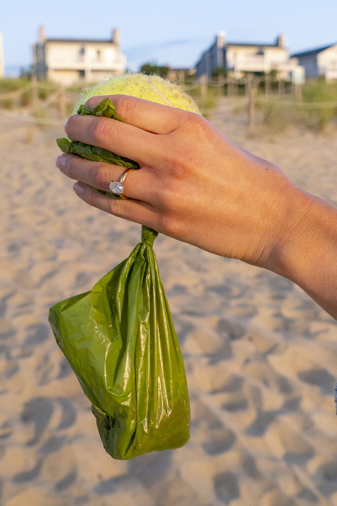 a person holding a bag of sand and a tennis ball