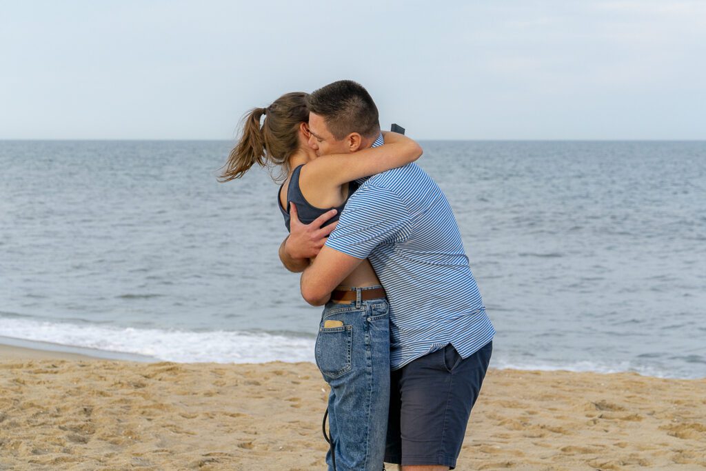 a man and a woman hug on the beach