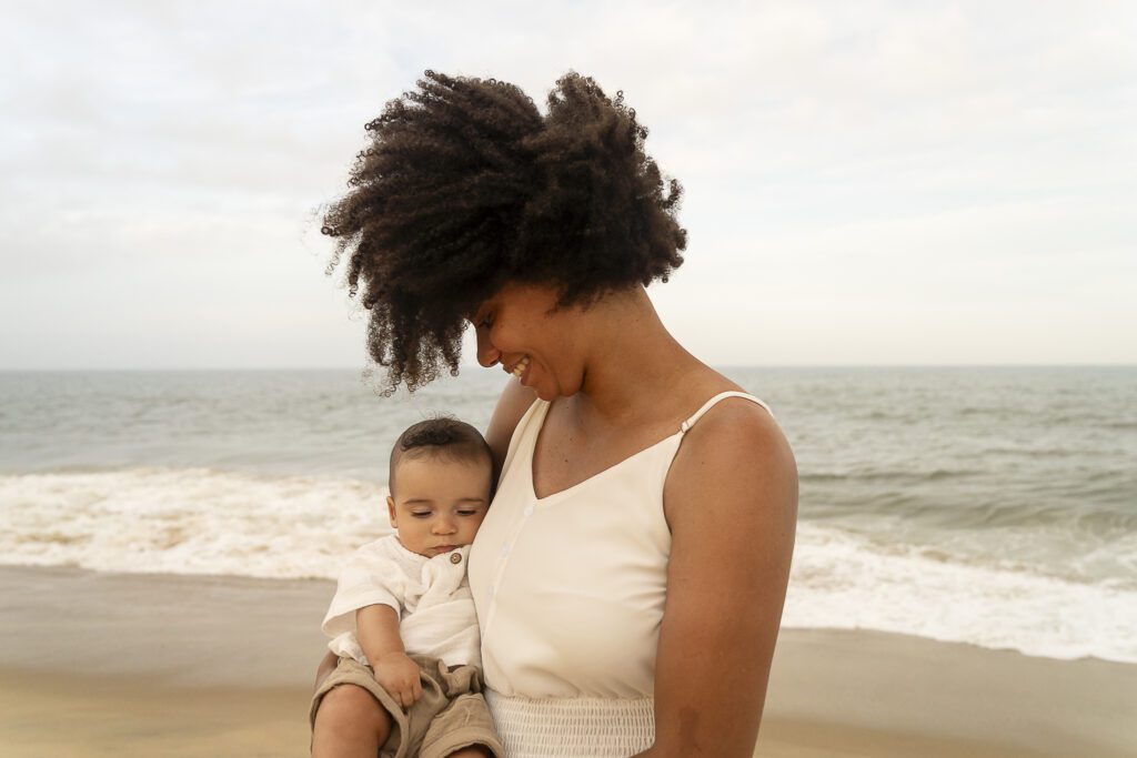 a woman holding a baby on the beach