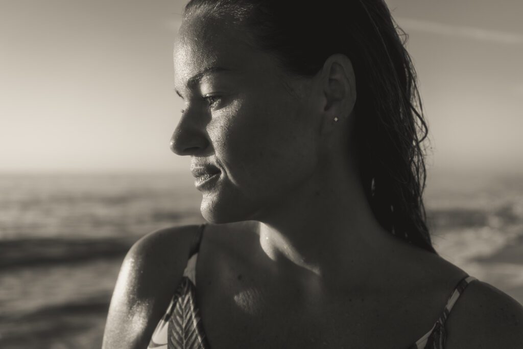 a black and white photo of a woman on the beach