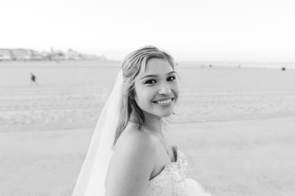 a woman in a wedding dress standing on a beach