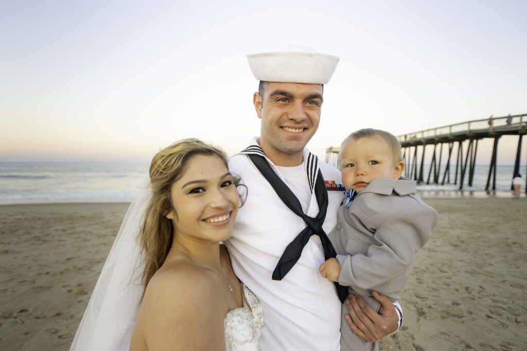 a man and woman pose for a picture on the beach