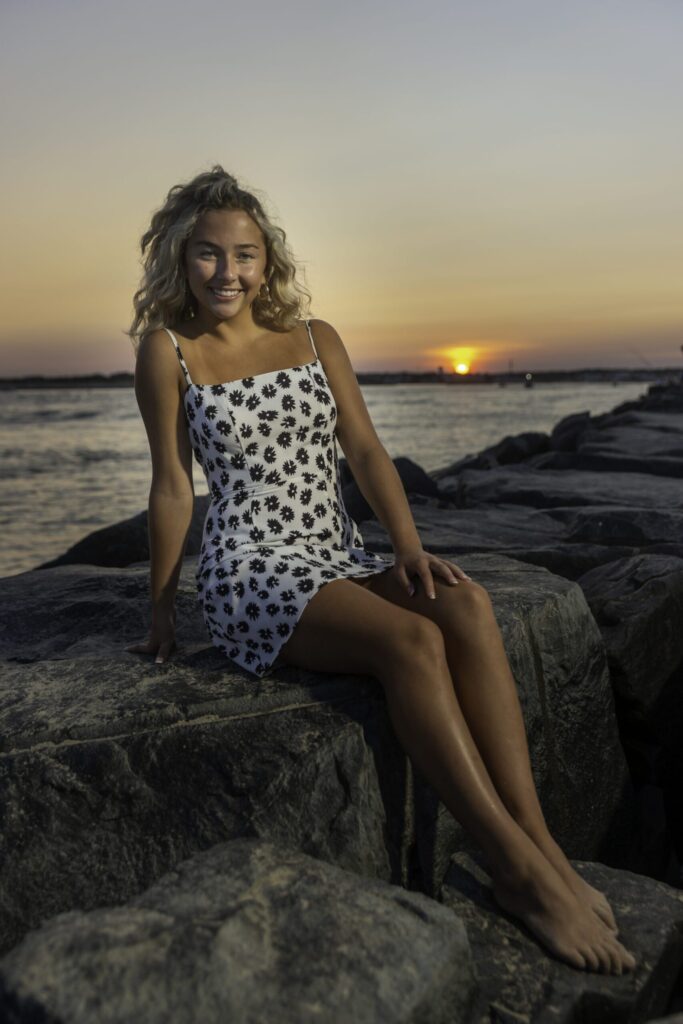 a woman sitting on a rock next to the ocean